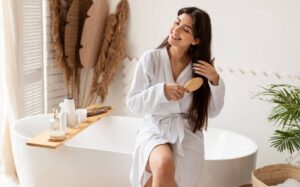 brunette-female-brushing-hair-with-hairbrush-sitting-bathtub-indoor_wp